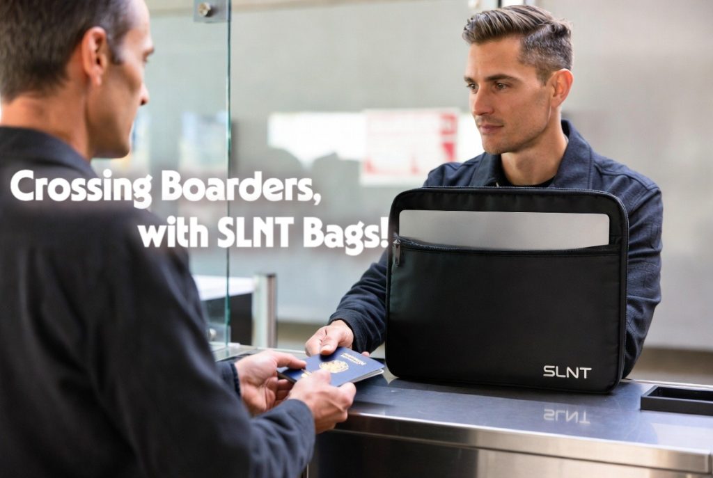 A traveler presenting a passport next to a laptop secured in a SLNT Faraday sleeve to prevent unauthorized digital border searches.